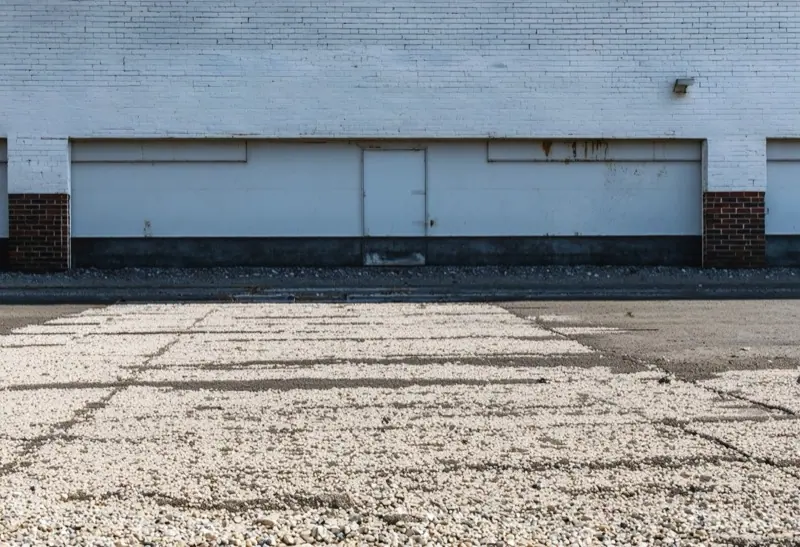 Tar and gravel built-up roof along a brick parapet wall